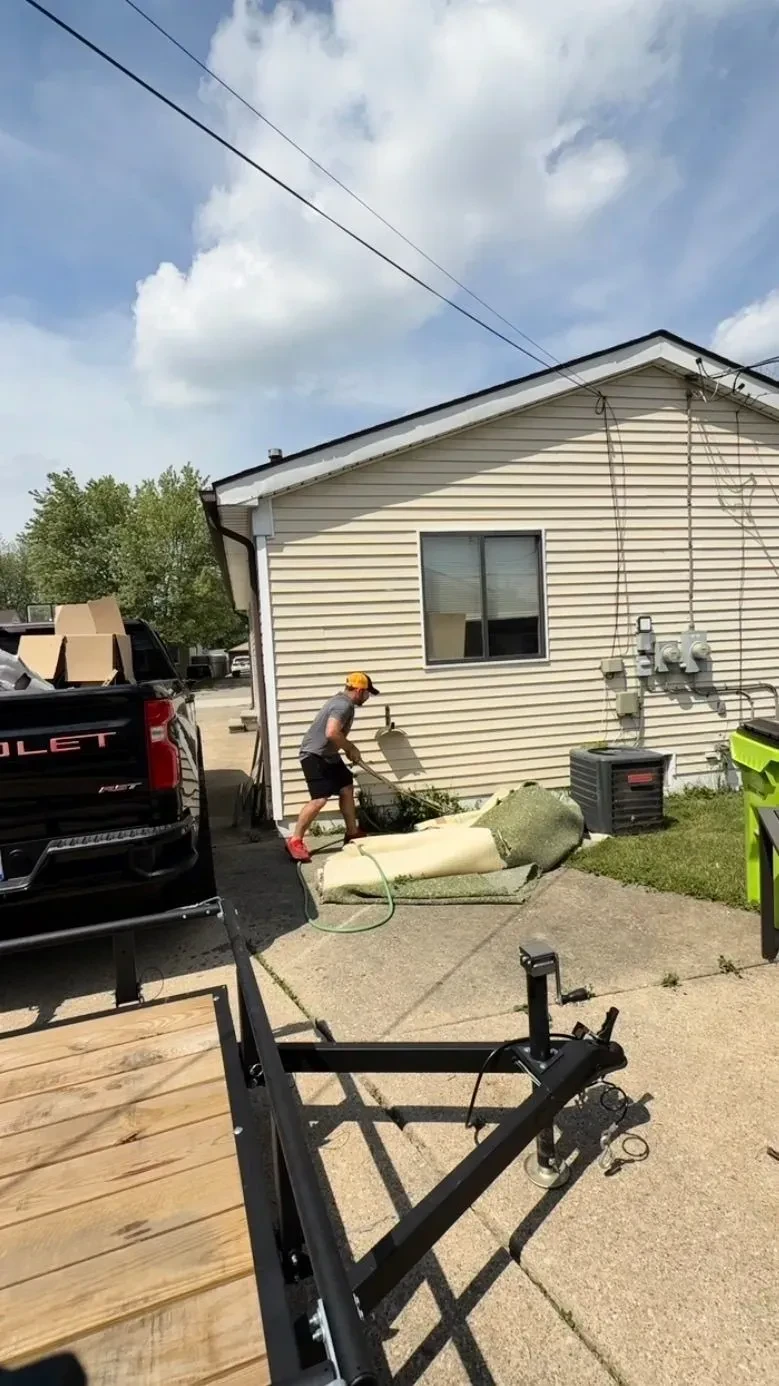 Old carpet and padding pulled up and staged for removal during a bulky household junk removal in Roseville, Michigan