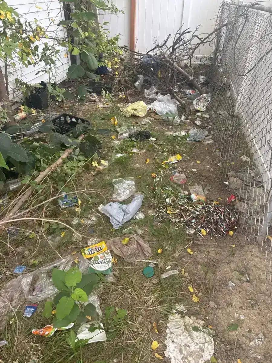 Garage exterior and adjacent paved area after trash and weeds were removed