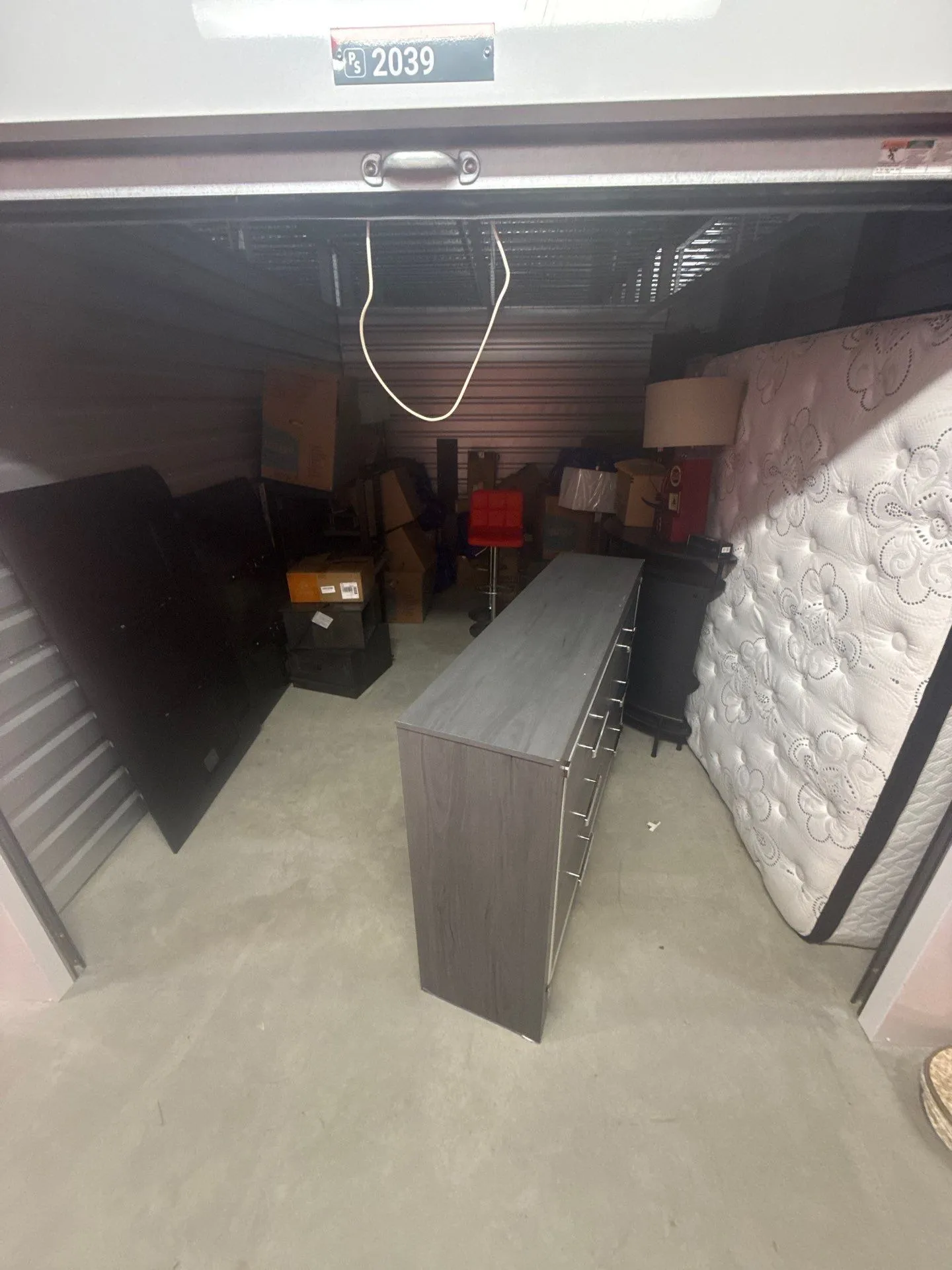 Second-story storage unit filled with boxes, furniture, a mattress and other belongings before removal