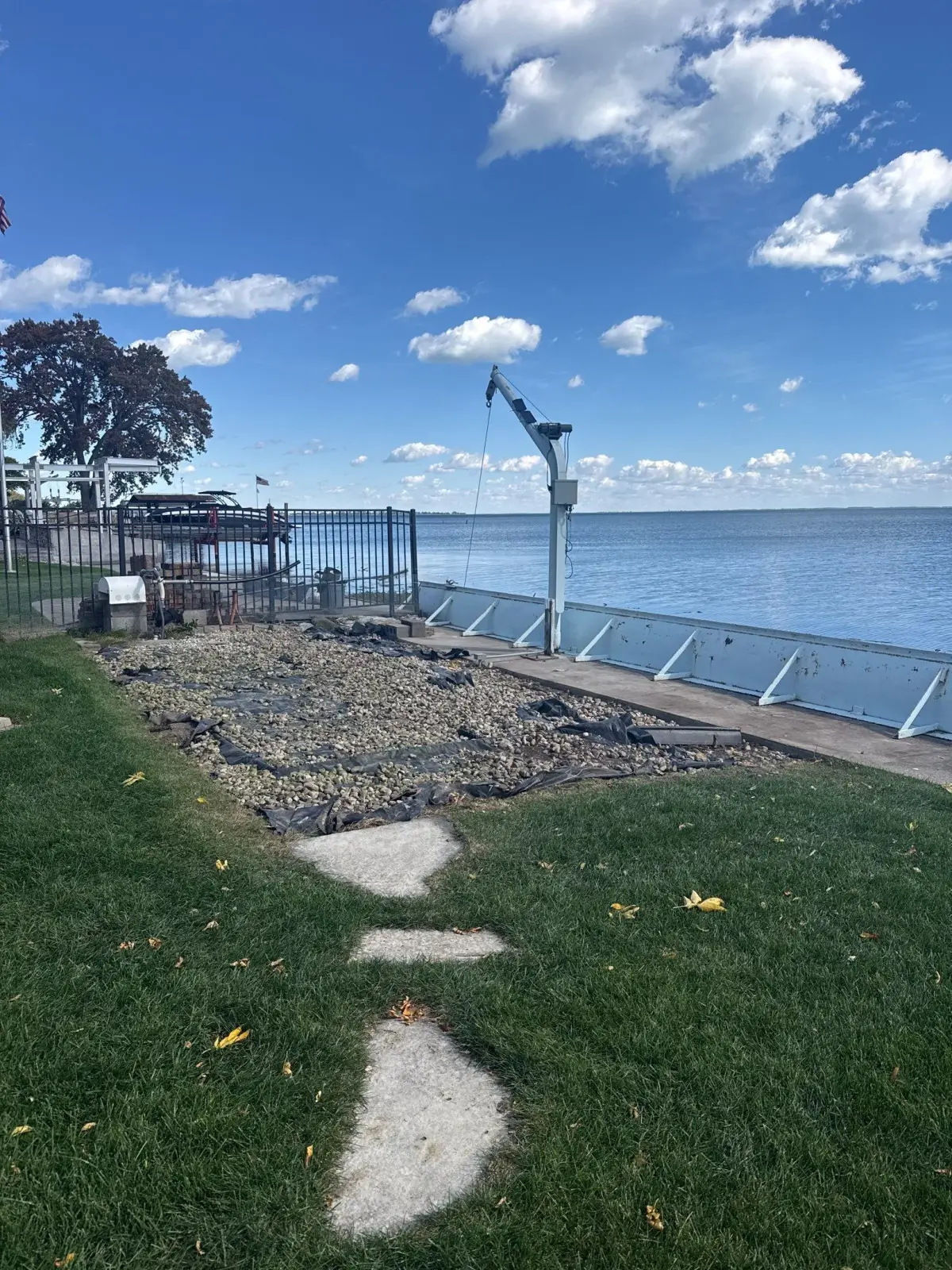 Cleared Harrison Township waterfront area with gravel, rock and landscape fabric, with the boat hoist and seawall still in place
