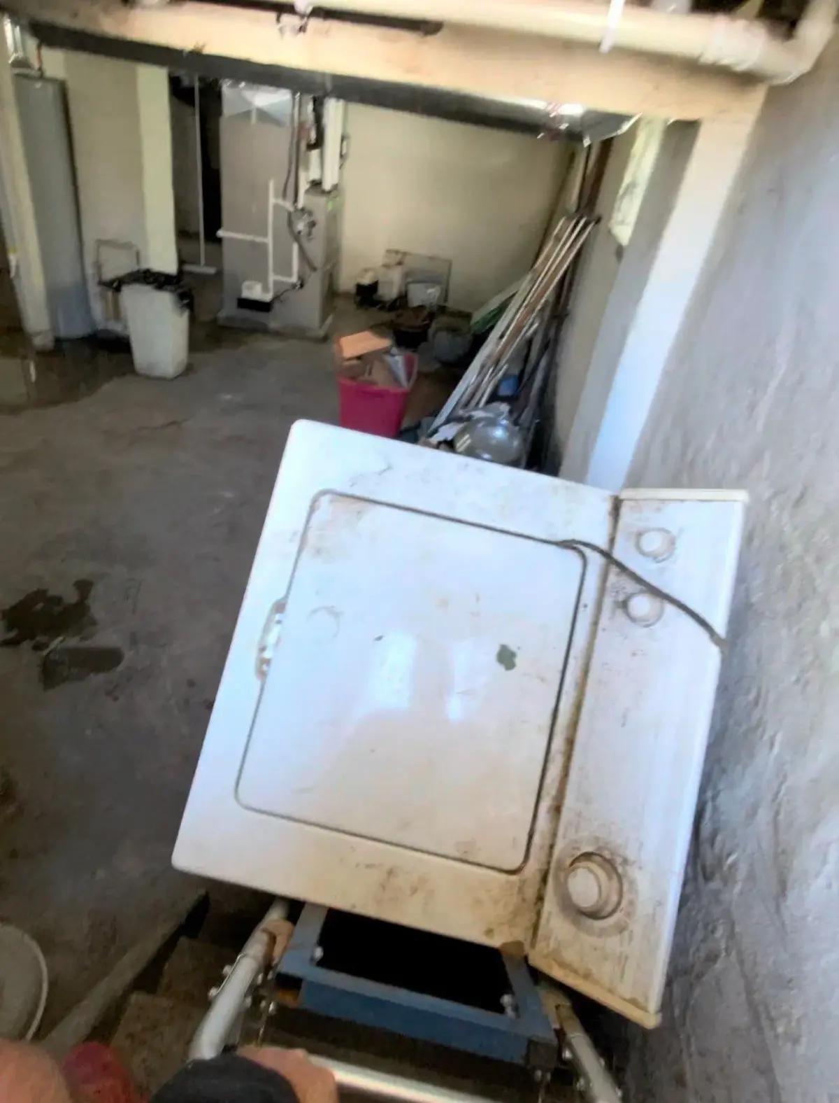 Washing machine strapped to a dolly at the basement stairs during carry-out in St. Clair Shores