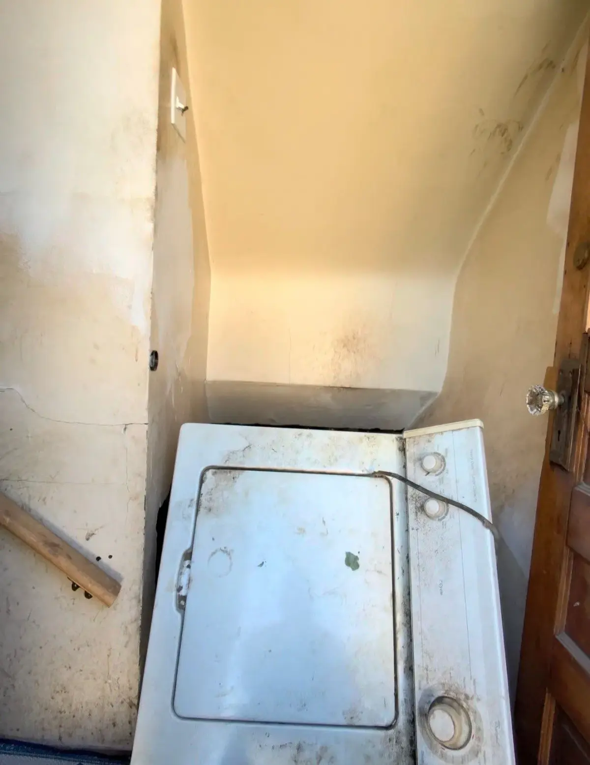 Washing machine at the top of the basement stairs on the landing during carry-out in St. Clair Shores