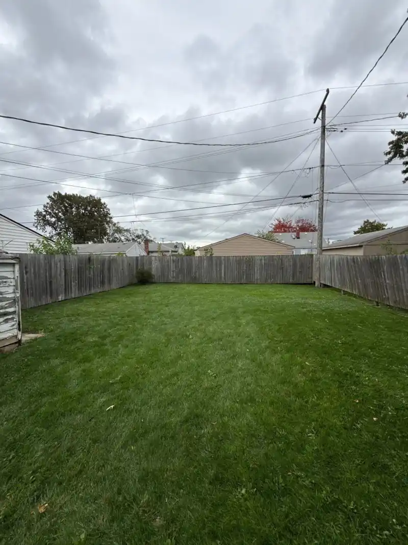 Wooden privacy fence along the driveway before demolition