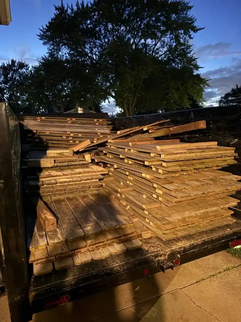 Removed wooden fence panels stacked in a trailer for haul-away